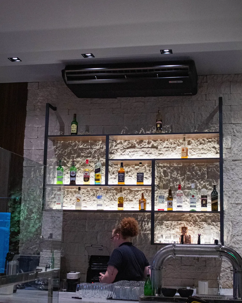 Bar da D'Angelo com prateleiras iluminadas