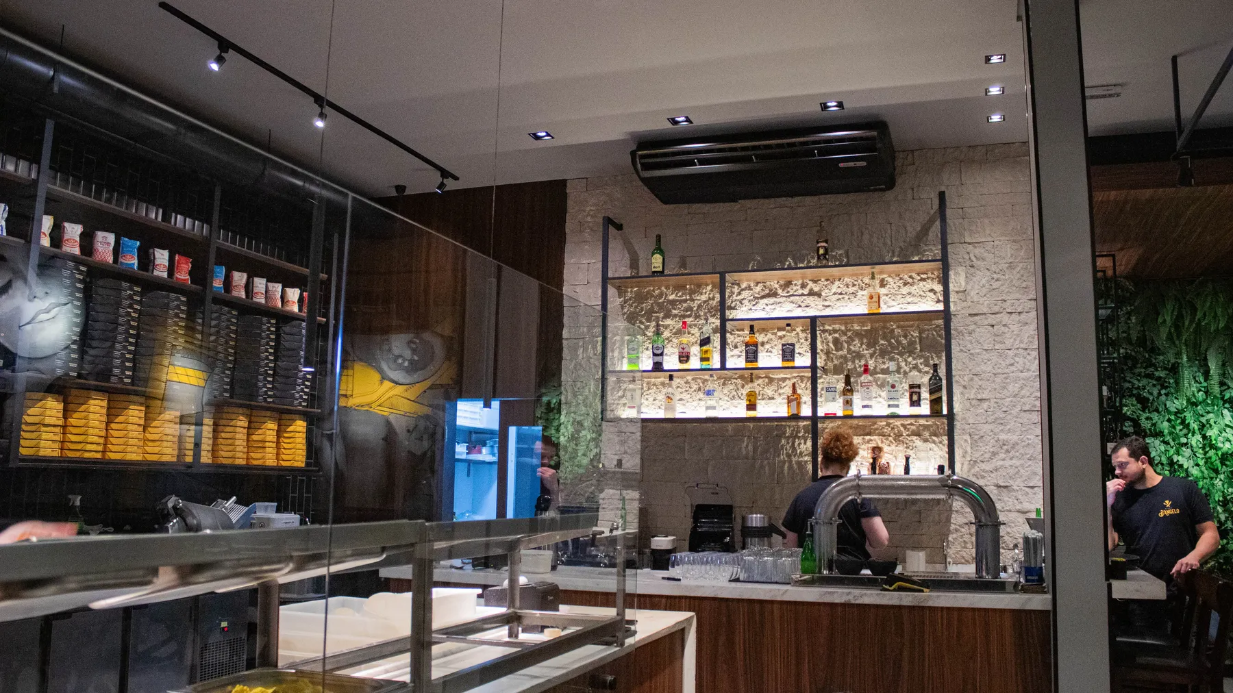 Cozinha aberta e bar vistos do salão